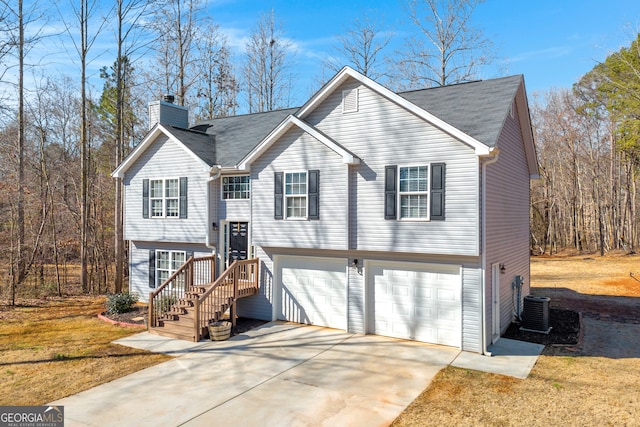 raised ranch with central AC, a garage, and a front yard