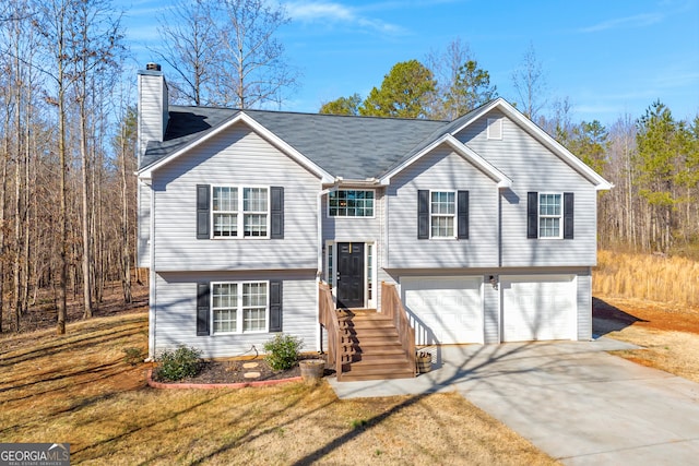 split foyer home with a garage and a front lawn