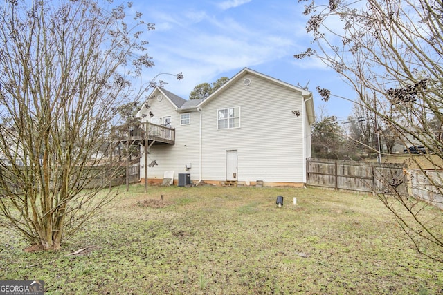 back of property featuring central air condition unit and a lawn