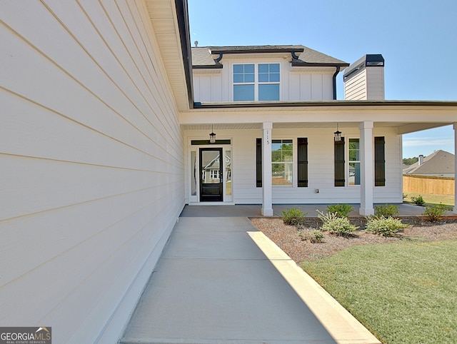 doorway to property featuring a porch and a yard