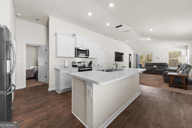 kitchen with sink, white cabinetry, vaulted ceiling, an island with sink, and stainless steel appliances