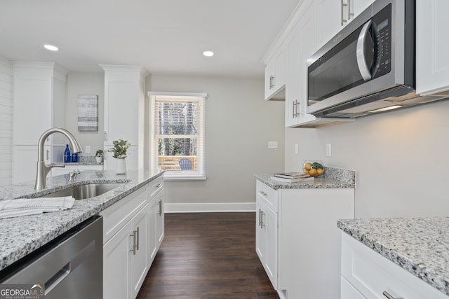 kitchen with sink, stainless steel appliances, white cabinets, and light stone countertops