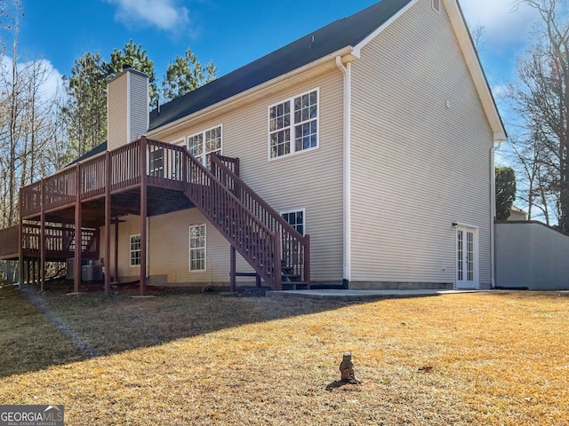 rear view of property with a yard and a deck