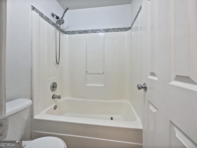 bathroom featuring shower / tub combination and toilet