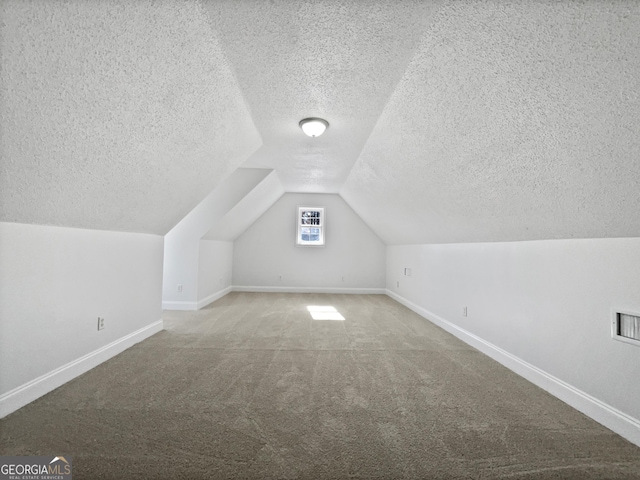 bonus room featuring lofted ceiling, carpet floors, and a textured ceiling