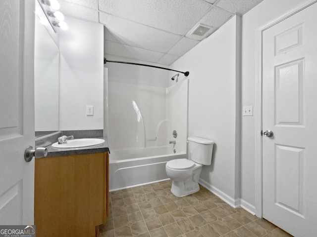 full bathroom featuring toilet, vanity, bathtub / shower combination, and a drop ceiling