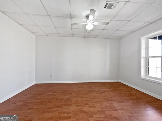 empty room featuring ceiling fan, a paneled ceiling, and wood-type flooring