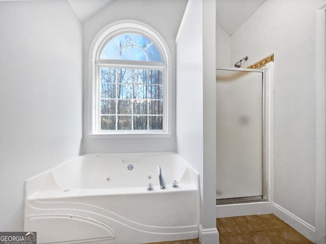 bathroom featuring independent shower and bath, vaulted ceiling, and tile patterned floors