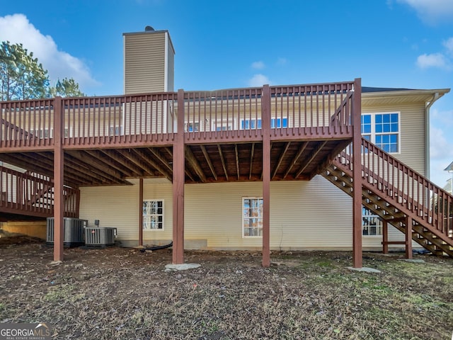 rear view of house featuring a wooden deck and central AC unit