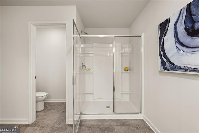 bathroom with toilet and a shower with shower door