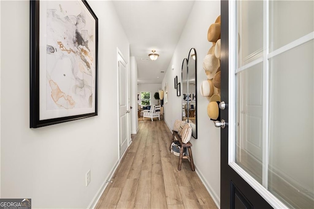 corridor with light hardwood / wood-style floors