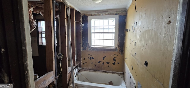 bathroom featuring a washtub and a textured ceiling