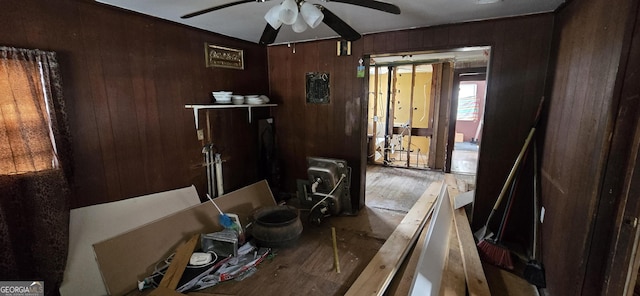 miscellaneous room featuring ceiling fan and wooden walls