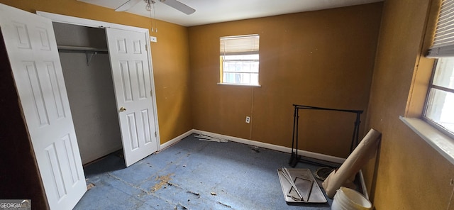 unfurnished bedroom with ceiling fan and a closet