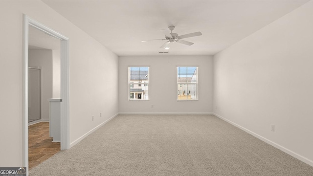 carpeted spare room with ceiling fan