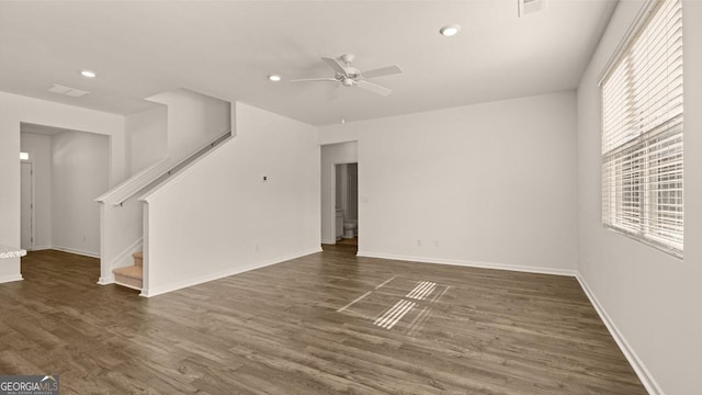 unfurnished living room with dark hardwood / wood-style flooring and ceiling fan