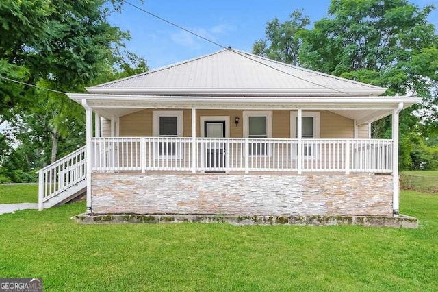 rear view of house with covered porch and a lawn