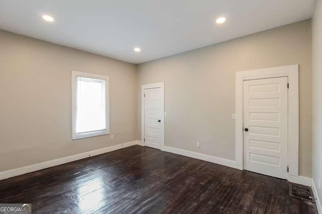 unfurnished room with dark hardwood / wood-style flooring