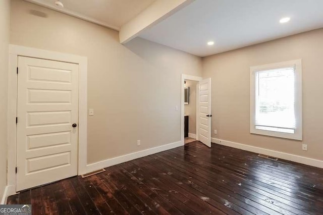 unfurnished bedroom featuring dark hardwood / wood-style flooring and beam ceiling