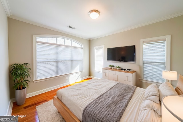 bedroom with hardwood / wood-style floors and crown molding