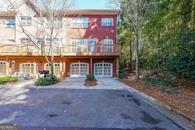 view of property with brick siding, driveway, and an attached garage