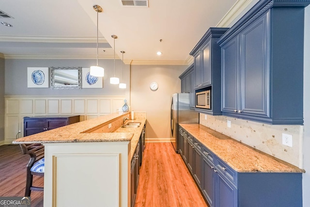 kitchen with light stone counters, crown molding, stainless steel appliances, hanging light fixtures, and blue cabinets