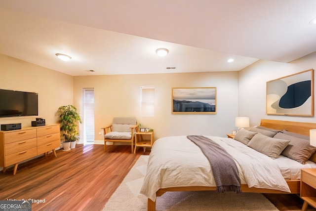 bedroom featuring baseboards, wood finished floors, visible vents, and recessed lighting