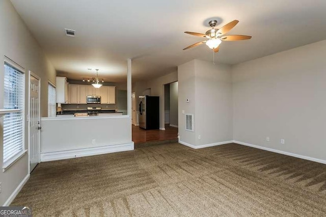 unfurnished living room with ceiling fan and dark colored carpet