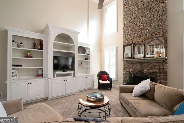 living room with light colored carpet, a fireplace, and a towering ceiling