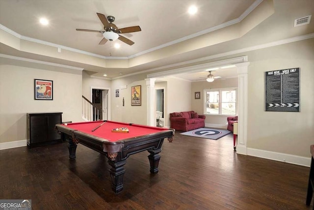 rec room featuring a raised ceiling, crown molding, dark hardwood / wood-style floors, and decorative columns