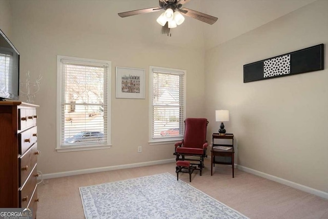 living area with light colored carpet and ceiling fan