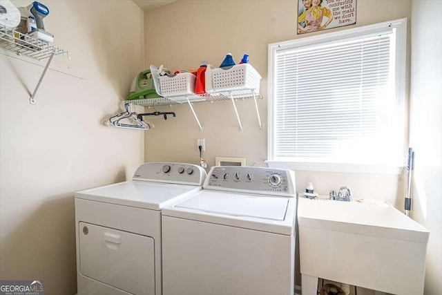 laundry area featuring washing machine and clothes dryer and sink