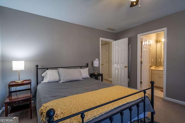 carpeted bedroom with connected bathroom, sink, and ceiling fan