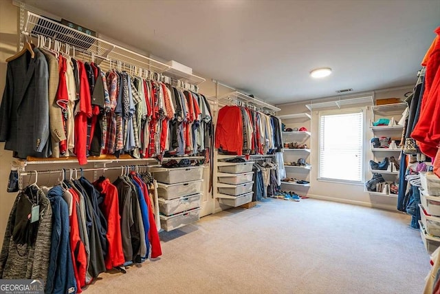 walk in closet featuring light colored carpet