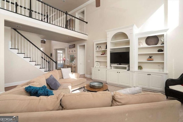 carpeted living room featuring built in features and a high ceiling