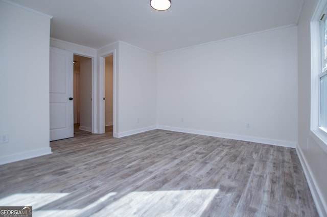 empty room featuring ornamental molding and light hardwood / wood-style floors