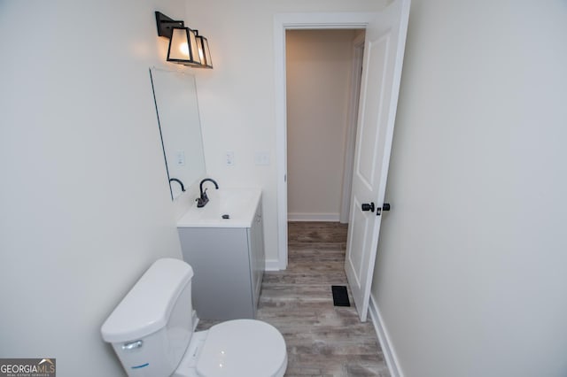 bathroom featuring hardwood / wood-style flooring, vanity, and toilet