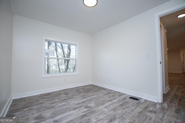 unfurnished room featuring crown molding and wood-type flooring