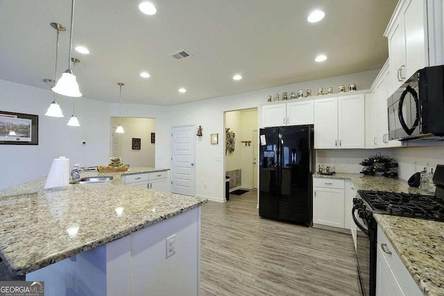 kitchen featuring sink, decorative light fixtures, a center island, black appliances, and white cabinets