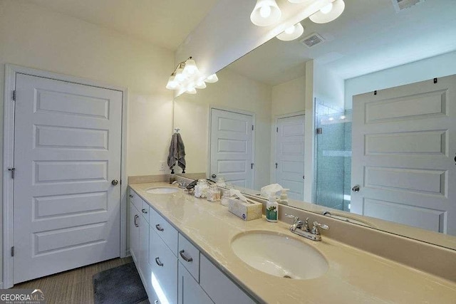 bathroom with wood-type flooring, a shower with shower door, and vanity