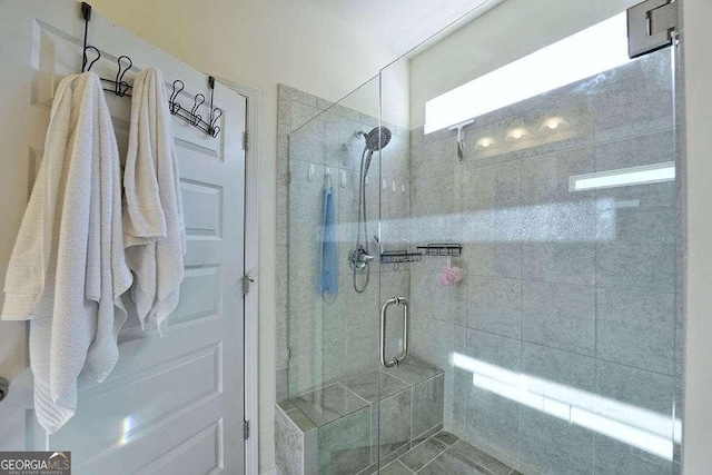 bathroom with a shower with door