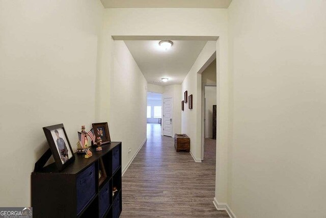 corridor with dark hardwood / wood-style flooring