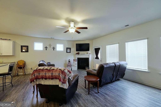 living room featuring dark wood-type flooring and ceiling fan