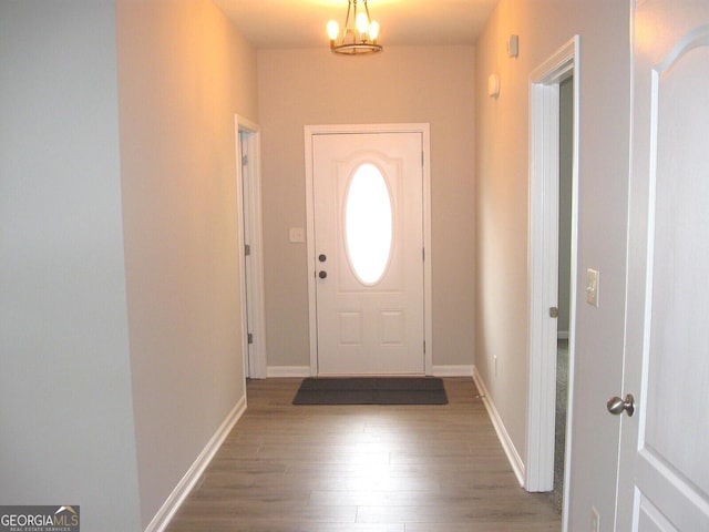 doorway featuring wood-type flooring and a chandelier