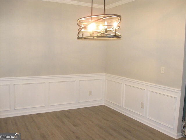 unfurnished dining area featuring ornamental molding, dark hardwood / wood-style floors, and a chandelier