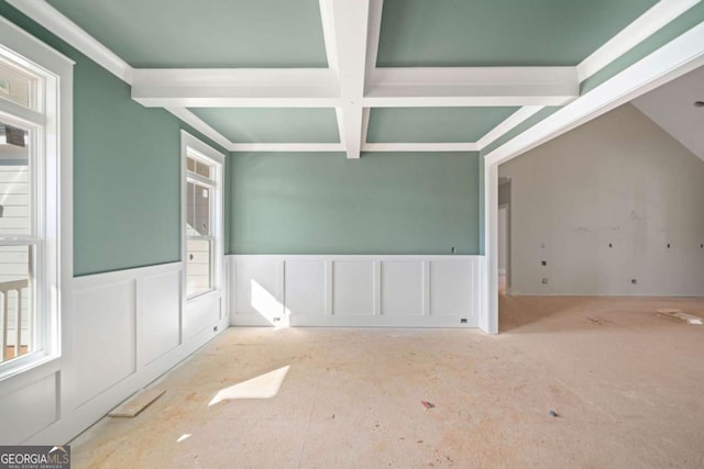 empty room featuring beamed ceiling, a healthy amount of sunlight, and coffered ceiling