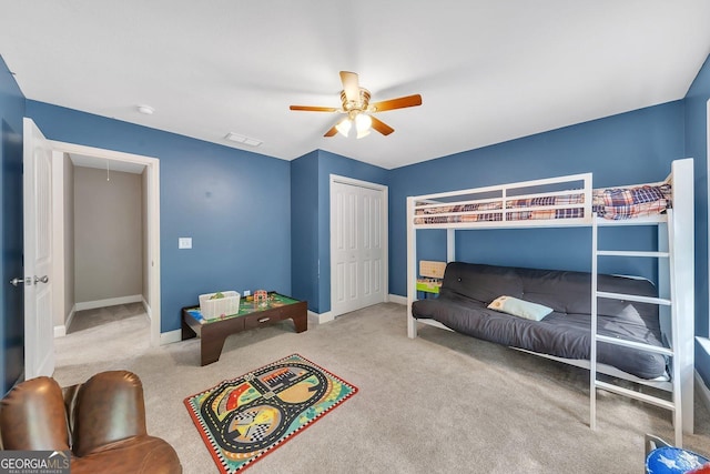 carpeted bedroom featuring ceiling fan and a closet