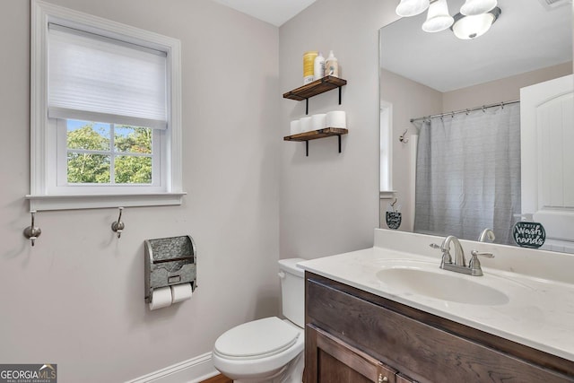 bathroom featuring vanity, a notable chandelier, and toilet