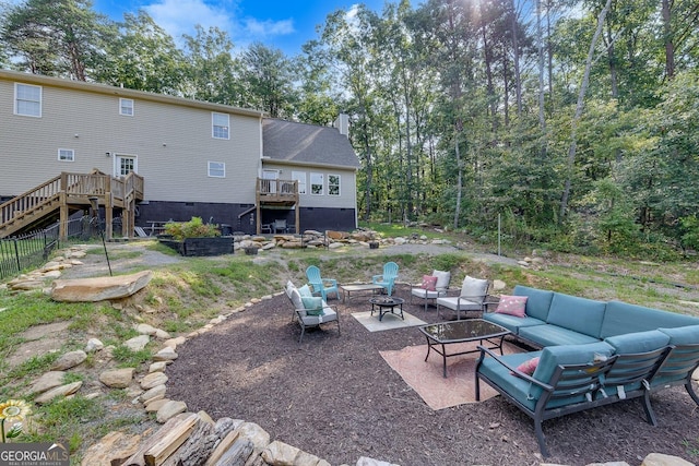 view of patio with a wooden deck and an outdoor living space with a fire pit