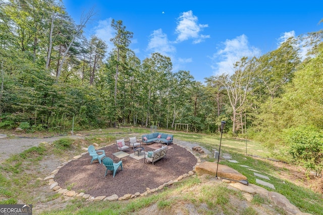 view of yard with an outdoor living space with a fire pit